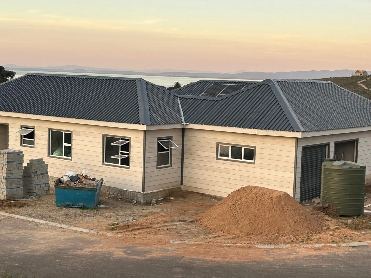 Large completed fibre-cement home with dark roof